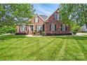Inviting brick home with a lush green lawn and black shutters, showcasing classic curb appeal at 3011 Patrick Place Cir, Clover, SC 29710