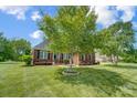 Traditional brick home with landscaped front yard, mature trees, and charming front entrance with flower accents at 3011 Patrick Place Cir, Clover, SC 29710