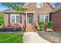 Close-up of a brick front porch with decorative plants and a stylish front door at 3011 Patrick Place Cir, Clover, SC 29710