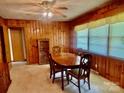 Traditional dining room with wood paneling, classic furniture, and a ceiling fan at 309 E Stevens Rd, Kershaw, SC 29067