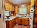 Cozy kitchen with wooden cabinets, white countertops, brick floors, and modern appliances at 309 E Stevens Rd, Kershaw, SC 29067