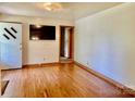 Bright living room featuring hardwood floors, a mounted TV, and fresh paint at 309 E Stevens Rd, Kershaw, SC 29067