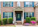 Charming front entryway with brick facade, blue door, and colorful landscaping, showcasing a welcoming entrance at 3095 Foggy Hollow Ln, Clover, SC 29710