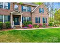 Lovely home featuring a well-maintained lawn, colorful flowers, and brick facade, creating inviting exterior at 3095 Foggy Hollow Ln, Clover, SC 29710