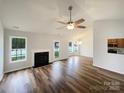 Open-concept living room with vaulted ceiling, fireplace, and natural light, flowing into the dining area at 4147 Timberwood Dr, Gastonia, NC 28056