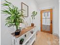 Entryway with a wood door, console table decorated with plants, and light hardwood flooring at 4189 Brandy Creek Ct, Clover, SC 29710