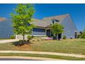 Charming exterior with a manicured lawn, blooming flowers, and a two-car garage at 4502 Middlebury Ln, Fort Mill, SC 29715
