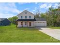 Charming two-story white farmhouse with a covered porch and attached garage at 7205 Church Rd, Taylorsville, NC 28681