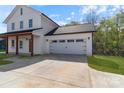 Close up of an attached white garage with black accents and a concrete driveway at 7205 Church Rd, Taylorsville, NC 28681