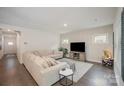 Inviting living room featuring hardwood floors, a large sectional, and a modern entertainment center at 7518 Porrera St, Charlotte, NC 28214