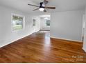 Bright, open room with hardwood flooring and natural light and views to a connected dining space at 827 Ford Dr, Lowell, NC 28098