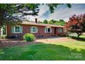 Classic brick ranch-style home featuring green shutters, mature landscaping, and a well-manicured lawn at 904 Sunbeam Dr, Lincolnton, NC 28092