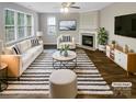 Bright living room with stylish furnishings, a cozy fireplace, and large windows offering ample natural light at 9527 Scotland Hall Ct, Charlotte, NC 28277