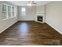 Spacious living room with a fireplace, hardwood flooring and large windows providing an airy and inviting atmosphere at 9527 Scotland Hall Ct, Charlotte, NC 28277