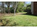 Lush, green backyard with trees and partial view of deck with a pergola at 9915 Lottie Ln, Charlotte, NC 28262