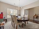 Bright dining area with classic round table and chairs, illuminated by natural light from a large window at 13510 Brandon Trail Dr, Charlotte, NC 28213