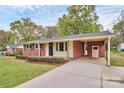 Brick home featuring an attached carport and mature landscaping with shrubs along the front of the house at 140 Mickle Ct, Rock Hill, SC 29732