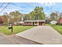 Expansive driveway leading to a well-kept brick home with a large front lawn and mature trees at 140 Mickle Ct, Rock Hill, SC 29732