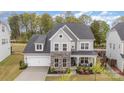 Charming two-story home with stone accents, a well-manicured lawn, and a welcoming front porch for relaxation at 15230 Ravenall Dr, Huntersville, NC 28078