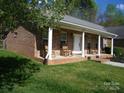 Inviting brick front porch with classic white columns and comfortable rocking chairs at 154 Tiger Oak Ln, Rockwell, NC 28138
