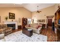 Spacious living room with hardwood floors, vaulted ceiling, a fireplace, and open access to dining area at 1713 12Th Ne St, Hickory, NC 28601