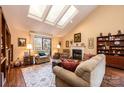 Bright living room featuring skylights, a fireplace, hardwood floors, and comfortable seating with access to a porch at 1713 12Th Ne St, Hickory, NC 28601