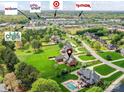 Aerial view of homes with pools, green lawns, and mature trees in the neighborhood with shopping close by at 1902 Windmere Dr, Monroe, NC 28110