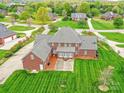 Back aerial view showcasing patio, lawn, and mature trees surrounding the property at 1902 Windmere Dr, Monroe, NC 28110