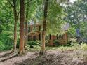 Brick home featuring mature trees, a landscaped front yard, and elegant architectural details at 2313 Beechwood Dr, Waxhaw, NC 28173