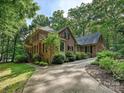 Elegant brick home with attached garage, lush landscaping, and a long driveway through mature trees at 2313 Beechwood Dr, Waxhaw, NC 28173