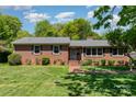 Classic brick home with lush green lawn, brick walkway, and mature trees highlighting the inviting facade at 3000 Imperial Dr, Gastonia, NC 28054