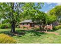 Well-manicured lawn with mature trees framing a charming brick home featuring a brick walkway at 3000 Imperial Dr, Gastonia, NC 28054