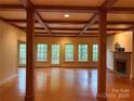 Spacious living room featuring hardwood floors, fireplace, and a wall of windows at 3011 Lakewood Edge Dr, Charlotte, NC 28269
