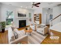 Bright living room featuring a fireplace, hardwood floors, ceiling fan and stylish furniture at 3114 Parker Green Trl, Charlotte, NC 28269
