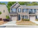 Charming brick townhome featuring a one car garage, blue shutters, and landscaped front yard at 3248 Park South Station Blvd, Charlotte, NC 28210