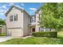 A two-story home with tan siding and a well maintained lawn, showcasing its curb appeal at 3882 Shasta Cir, Clover, SC 29710