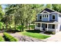 A view of the beautiful blue exterior, manicured lawn and wooded scenery at 420 Solomon St, Charlotte, NC 28216
