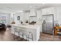 Modern kitchen with white cabinets, stainless steel appliances, a spacious island with seating, and a view to the dining area at 562 Amalfi Dr, Davidson, NC 28036