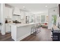 Bright, open kitchen features white cabinets, subway tile backsplash, stainless steel appliances, and a view to the living room at 562 Amalfi Dr, Davidson, NC 28036