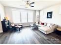Bright living room with hardwood floors, sectional sofa, ceiling fan, and large window at 562 Amalfi Dr, Davidson, NC 28036