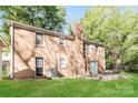 Brick home featuring a spacious backyard with a lush green lawn at 6001 Plaza Ln, Charlotte, NC 28215