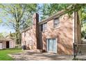 Expansive backyard of a brick home featuring mature trees and a concrete patio at 6001 Plaza Ln, Charlotte, NC 28215