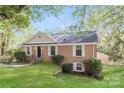 Charming brick home featuring a well-manicured lawn and traditional architectural details at 6001 Plaza Ln, Charlotte, NC 28215