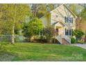 Yellow two-story house with a well-manicured lawn and inviting entrance steps at 6005 Lanai Ln, Tega Cay, SC 29708