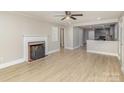 Inviting living room featuring wood-look floors, a cozy fireplace, and an open layout leading to the kitchen at 706 Lowell Ave, Lowell, NC 28098