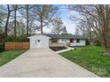 Attractive single-story home with a white brick facade, dark roof, and a concrete driveway at 908 Woodside Dr, Kings Mountain, NC 28086