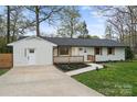 Inviting single-story home featuring a white brick facade, dark roof, and a concrete driveway at 908 Woodside Dr, Kings Mountain, NC 28086
