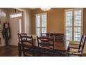Dining room with dark wood floors, shutters on windows, and traditional table and chairs at 9319 Kestral Ridge Dr, Charlotte, NC 28269