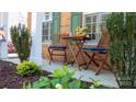 Quaint front porch with seating, green shutters, and brick columns in a landscaped setting at 9319 Kestral Ridge Dr, Charlotte, NC 28269