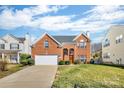 Charming two-story red brick home with attached garage and well-kept lawn, great curb appeal at 98 Poplar Woods Dr, Concord, NC 28027